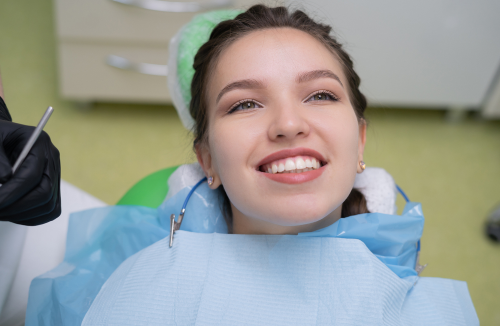 Young woman smiling in dental chair during appointment for dental implant evaluation – Dental Implants Roseville