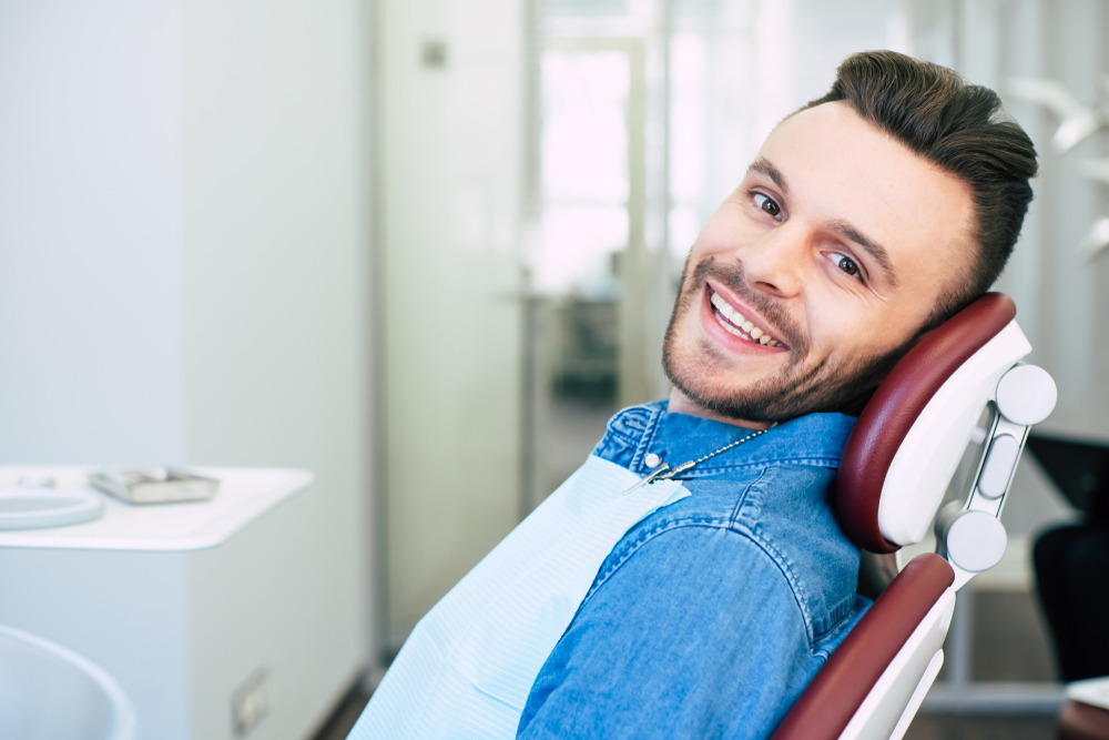 Draw the eye. A man is smiling while having a qualified dental treatment in a professional clinic