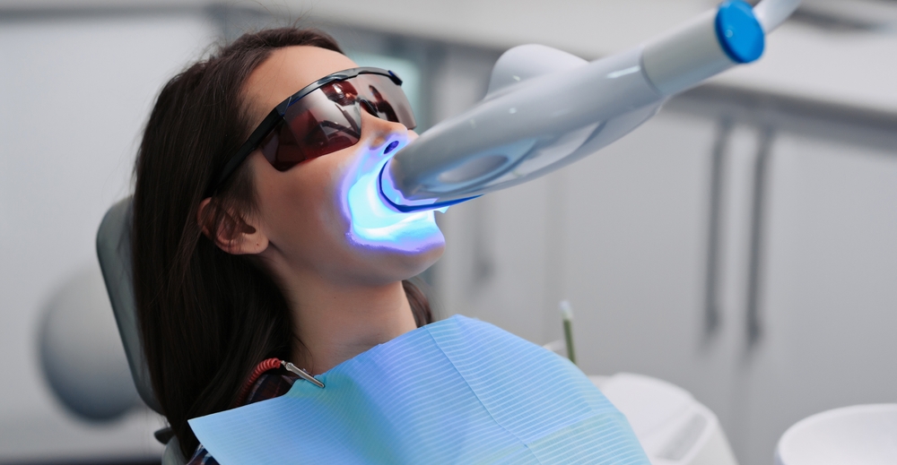 Teeth whitening for woman. Bleaching of the teeth at dentist clinic.
